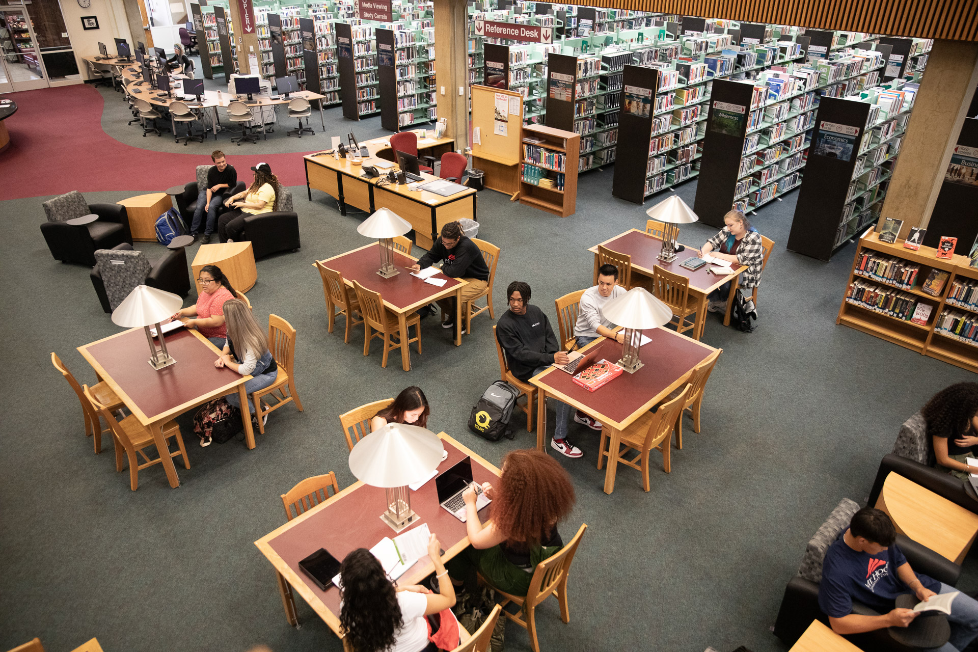 Students studying in the library at tables