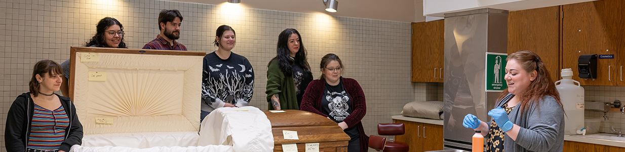 funeral service students standing around a casket