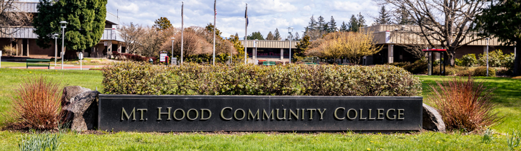 Outside the MHCC Gresham Campus with a sign that reads Mt. Hood Community College