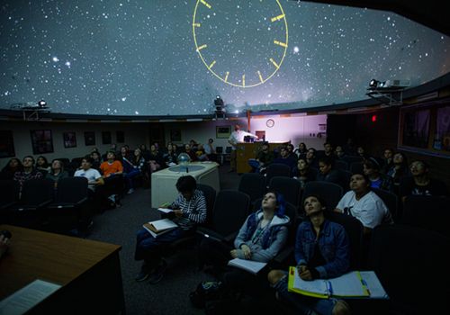 students sitting in planetarium