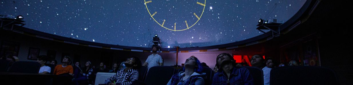 students sitting in planetarium